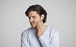 man in pain, example of someone with a dental emergency