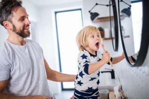 Parent helping child learn to brush