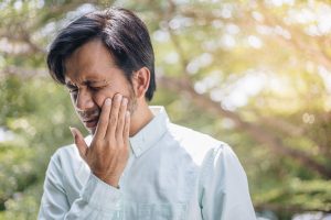 man suffering tooth pain